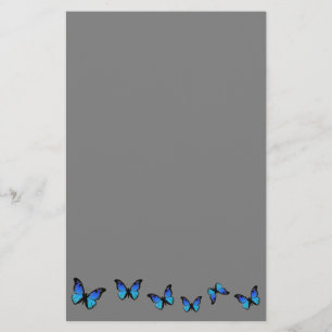 Papelería mariposas azules sobre fondo plateado