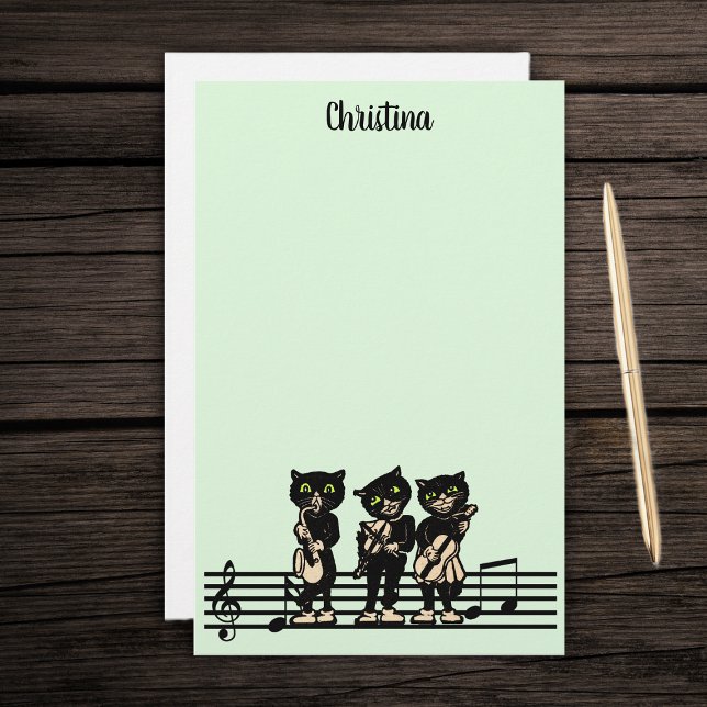 Papelería Tres músicos de gato negro instrumentos musicales  (Three black cat musicians playing instruments on bar of music notes on green stationery paper pad.)