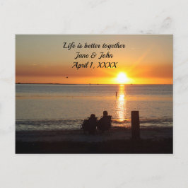 Pareja sentada en la playa al atardecer Tarjeta po