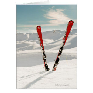 Pares rojos de esquí que se colocan en nieve