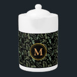 patrón de hojas botánicas verdes tetera negra<br><div class="desc">La tetera presenta un diseño cautivador con exuberantes hojas botánicas verdes entrelazadas en un elegante fondo negro, creando un ambiente armonioso y refrescante. Para añadir un toque de personalización, hemos adornado la tetera con un lujoso monograma dorado, mostrando elegantemente sus iniciales o nombre. Esta tetera, trabajada con cuidado, no es...</div>