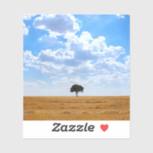 Pegatina Árbol en un campo de trigo cosechado