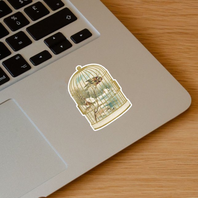 Pegatina Aves blancas de oro con nevada de ramas (Golden birdcage with bird overlooking winter cabin scene snow on vinyl sticker.)