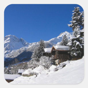 Pegatina Cuadrada Cabañas de troncos cubiertas de nieve en Suiza