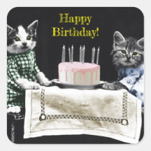 Cats celebrating a birthday with cake and candles