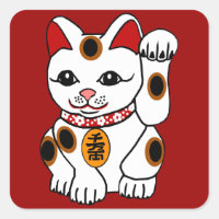 El gato Maneki Neko sobre fondo rojo