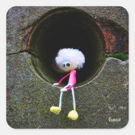 Pegatina Cuadrada Fubby poppetje dat in een muur zit.