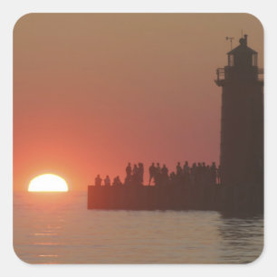 Pegatina Cuadrada Gente faro puesta de sol silueta en el sur