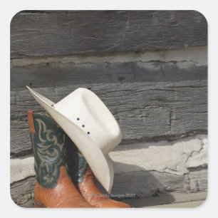 Pegatina Cuadrada Gorra de vaquero con botas de vaquero afuera de la