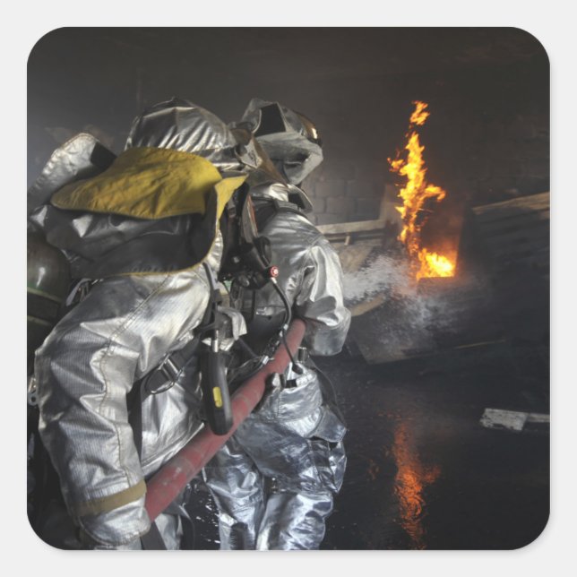 Pegatina Cuadrada Los bomberos extinguen un incendio en un entrenami (Anverso)