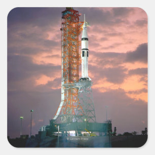 Pegatina Cuadrada Roturas del amanecer detrás de ASTP Saturn IB CDD