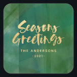 Pegatina Cuadrada Saludos de las temporadas metálicas de oro<br><div class="desc">Temporadas metálicas de oro saludos Navidades / diseño de vacaciones. Con detalles verdes pintados a mano y texto de guión de efecto oro. Este diseño moderno forma parte de una colección de vacaciones de coordinación.</div>