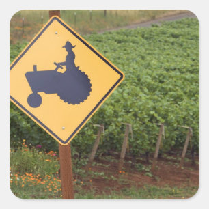 Pegatina Cuadrada Una señal de cruce de tractor amarillo en el viñed