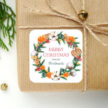 Pegatina Cuadrada Vacaciones de color de agua Wreath Merry Christmas<br><div class="desc">Este pegatina de vacaciones personalizado cuenta con una acuarela de guirnaldas y vegetación, que incluye naranjas, galletas, dulces y un hombre de pan de jengibre, además de pinares, bayas y algodón de siempre verde. Las palabras "Feliz Navidad" aparecen en letra roja de serif. Personalice el diseño con su apellido en...</div>