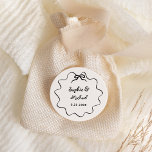 Pegatina Redonda Amour | Boda de Bow francés ilustrado<br><div class="desc">Este elegante pegatina de moda y novios cuenta con un marco dibujado a mano,  con una ondulación ilustrada,  y un guión elegante escrito a mano para una invitación a una boda de estilo parisino o francés. Esta opción clásica de color es marfil y negro.</div>