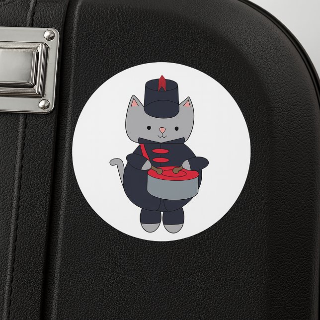 Pegatina Redonda Banda de Música Gato Gris Tambor Azul Marino Rojo (A sticker featuring a cat playing the drums in a navy blue and red marching band uniform.)