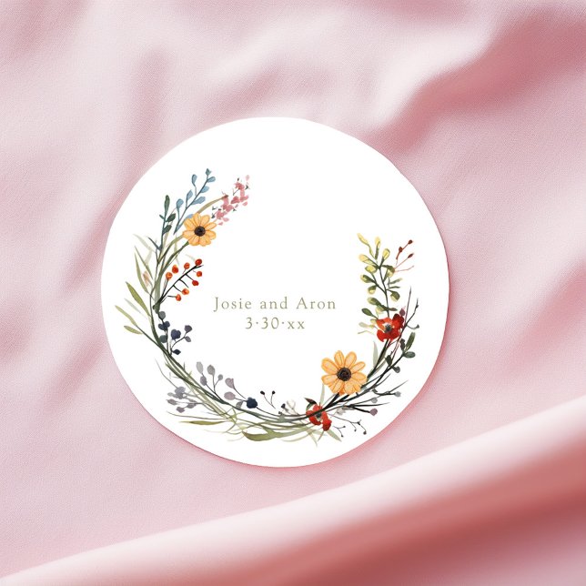 Pegatina Redonda Boda de flores silvestres de bonito Nombres de gui (Round sticker with vibrant wildflower wreath and delicate wedding names and date in center.)