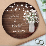 Pegatina Redonda Boda de Mason Jar y Luces Rusticas<br><div class="desc">El diseño está decorado con una suave acuarela de flores de aliento de bebé en un jarrón de carmín sobre un fondo rústico de madera con luces de cuerda. Haga clic en el botón personalizar para obtener más flexibilidad al modificar el texto o mover los gráficos. Las variaciones de este...</div>