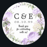 Pegatina Redonda Boda Monogramado Purple Floral Gracias<br><div class="desc">Rosas púrpura y flores blancas están enclavadas en brotes y vegetación para crear una corona romántica. Las iniciales de su pareja, la fecha boda y la declaración de agradecimiento están en el centro. Sello perfecto para sus notas de agradecimiento o favores de boda. Forma parte de la colección Violette que...</div>