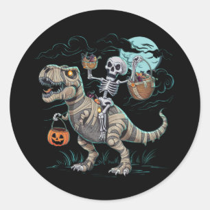 Pegatina Redonda Calabaza de Halloween con esqueleto montando dinos
