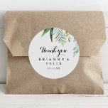 Pegatina Redonda Calligrafía verde gracias a favor de la boda<br><div class="desc">Esta caligrafía tropical le agradecemos la boda a favor de pegatina redondo clásico es perfecto para un boda moderno. El diseño se caracteriza principalmente por hojas tropicales verdes. Haga que el pegatina le asigne las etiquetas propias, incluyendo sus nombres, el evento (si procede) y la fecha. ¡Estos pegatinas pueden complementar...</div>