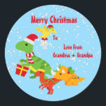 Pegatina Redonda Cute Merry Christmas Dinosaur Kids<br><div class="desc">Un lindo pegatina festivo de Navidades de dinosaurios festivos que muestra a un lindo personalizado de dinosaurios usando sombreros de santa y llevando un regalo o campanas con frases de Feliz Navidad arriba, y un fondo festivo de nieve azul. Perfecto para añadir como pegatina de nombre a cualquier regalo de...</div>