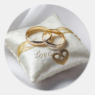 Pegatina Redonda Dos anillos bodas sobre una almohada blanca