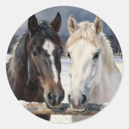 Pegatina Redonda Dos caballos en una granja nevada bajo la luz de l