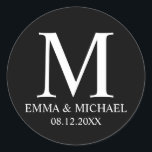 Pegatina Redonda Elegante blanco y negro en favor de la boda en un<br><div class="desc">Un diseño elegante y moderno en blanco y negro que presenta su monograma,  nombre y fecha con un estilo de fuente profesional blanco sobre fondo negro.</div>