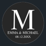 Pegatina Redonda Elegante blanco y negro en favor de la boda en un<br><div class="desc">Un diseño elegante y moderno en blanco y negro que presenta su monograma,  nombre y fecha con un estilo de fuente profesional blanco sobre fondo negro.</div>