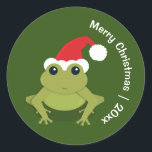 Pegatina Redonda Frog Santa Merry Christmas<br><div class="desc">Pegatinas navideñas divertidas mostrando una rana sonriente con un sombrero de Papá Noel en un fondo verde. Estos lindos pegatinas tienen las palabras ‘Feliz Navidad’ y un año de personalizable. Frog Santa Merry Navidad Clásico Ronda Pegatina Vacacional Diseño | ©Melissa Patton - Artista/Ilustrador</div>