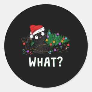 Pegatina Redonda Gato negro divertido empujando el árbol de Navidad