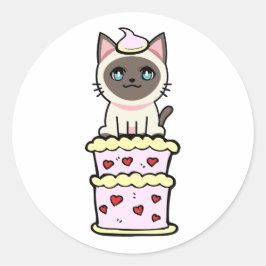 Pegatina Redonda Gracioso gato siamés saltando de un pastel