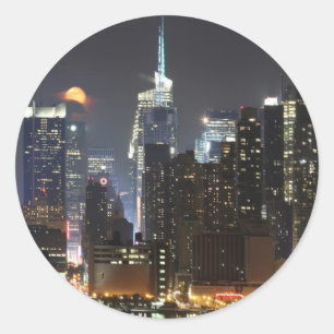 Pegatina Redonda La luna sube sobre el Midtown Nueva York.