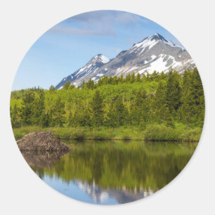 Pegatina Redonda Los Picos De Montaña Se Reflejan En Un Estanque D
