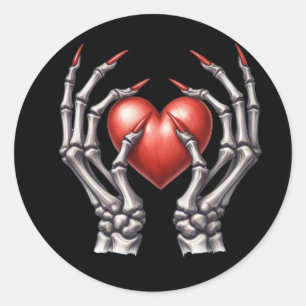 Pegatina Redonda Manos de esqueleto sosteniendo el corazón rojo