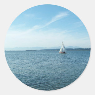 Pegatina Redonda mar y barco de vela bajo cielo azul