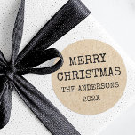Pegatina Redonda Merry Christmas name typewriter Kraft look<br><div class="desc">Navidades pegatinas de vacaciones presentando el texto "Feliz Navidad" y el nombre de su familia y el año siguiente en un tipo de letra estilo máquina de escribir en una imagen impresa El papel de Kraft tiene un aspecto de fondo.</div>
