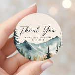 Pegatina Redonda Montañas acuarelas y Bodas De Pines Gracias<br><div class="desc">Expresar su gratitud con la tranquila belleza de las Montañas Watercolor y Boda Pines Gracias Pegatina Clásico Redondo. Este pegatina, impreso en material duradero, presenta una serena escena acuarela de montañas y pinos. Un sincero mensaje de 'Gracias', escrito en tipografía moderna, honra el centro del pegatina. Perfecto para sellar sus...</div>