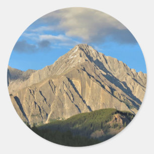 Pegatina Redonda Montañas y bosques asolados por el sol