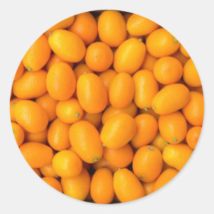 Pegatina Redonda Montón de kumquats naranjas en caja de cartón