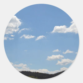 Pegatina Redonda Paisaje con colinas verdes, árboles y nubes