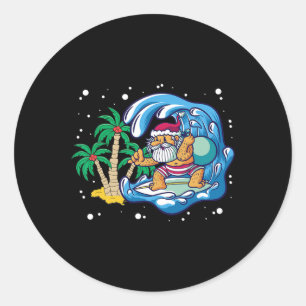 Pegatina Redonda Papá Noel de verano surfeando olas de playa Navida