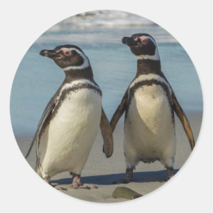 Pegatina Redonda Pareja de pingüinos en la playa