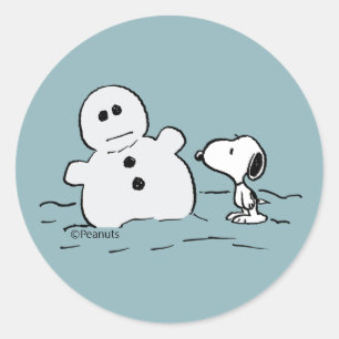 Pegatina Redonda Peanuts   Snoopy Construye Un Muñeco de Nieve