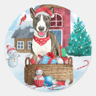 Pegatina Redonda Perro Bull Terrier en casa de Navidad con nieve