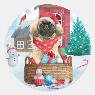 Pegatina Redonda Perro pequinés en casa de perro de Navidad con nie