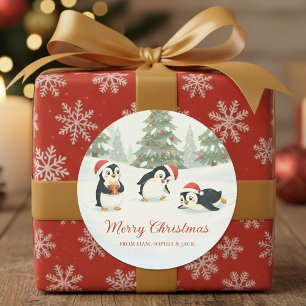 Pegatina Redonda Pingüinos adorables en Navidad con bosque de árbol