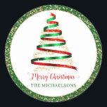 Pegatina Redonda Ribbon Merry Christmas Tree Gold Purpurina<br><div class="desc">Este pegatina festivo presenta un árbol de Navidad en rojo y verde con acento purpurina dorado. Texto "Feliz Navidad" en rojo. Perfecto para enviar saludos de temporada a todos los que estén en su lista.</div>
