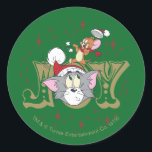 Pegatina Redonda Tom and Jerry Holiday Joy<br><div class="desc">Check out this fun graphic of Tom seen through the word "Joy" as Jerry stands atop his head,  playing with Tom's Santa hat!</div>
